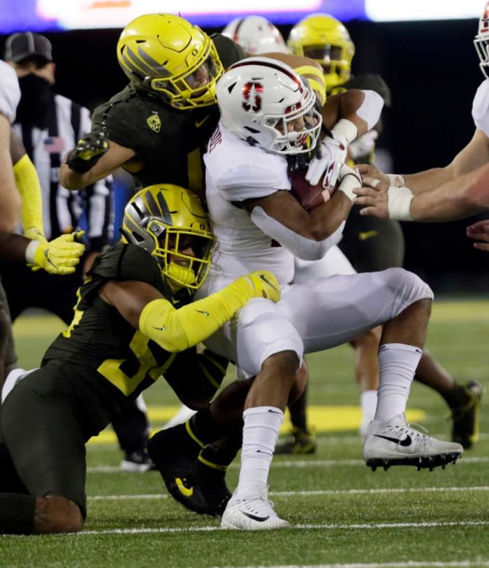 Dru Mathis (54) works with Isaac Slade-Matautia (41) to bring down Stanford running back Justus Woods.
